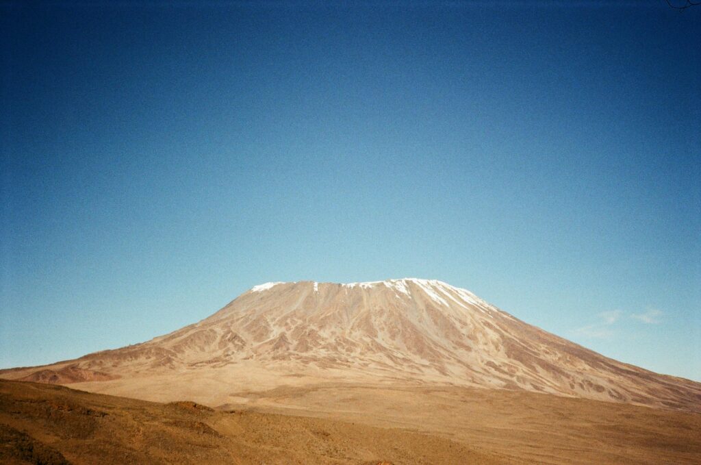 Stunning capture of Mount Kilimanjaro with its snowy peak against a clear blue sky in Tanzania.