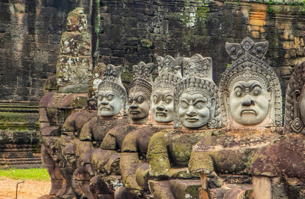 Close-up of detailed stone sculptures at Angkor Thom, a historic Khmer landmark in Cambodia.