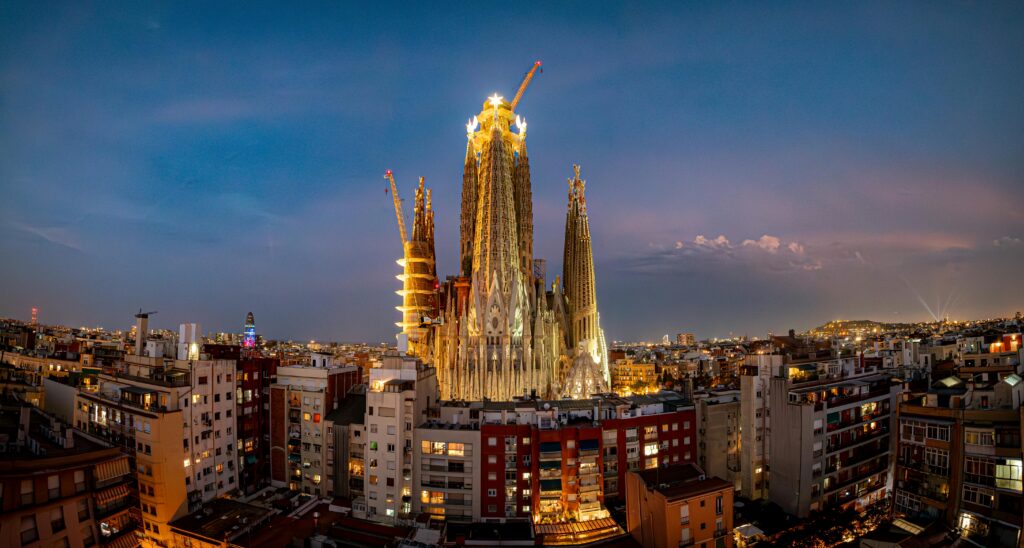 Sagrada Família illuminated at twilight in Barcelona, showcasing its intricate architecture against the cityscape.