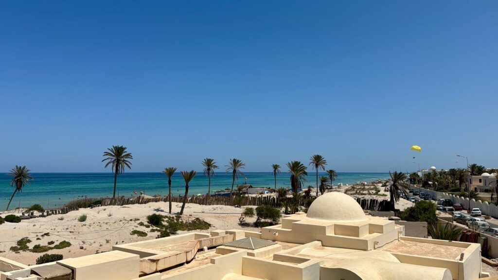 Idyllic beach scene in Médenine Governorate, Tunisia, showcasing clear skies and a vibrant seashore.